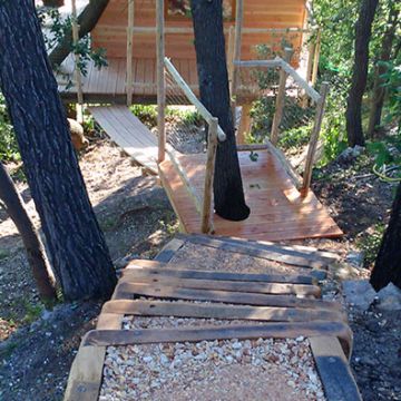 Aménagement d'un escalier en bois pour accéder à une cabane dans les arbres